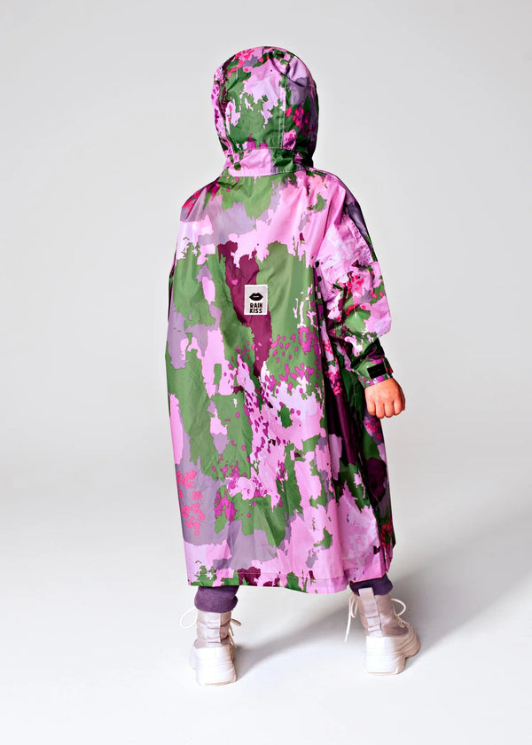 Person wearing a pink and green camouflage raincoat on a white background