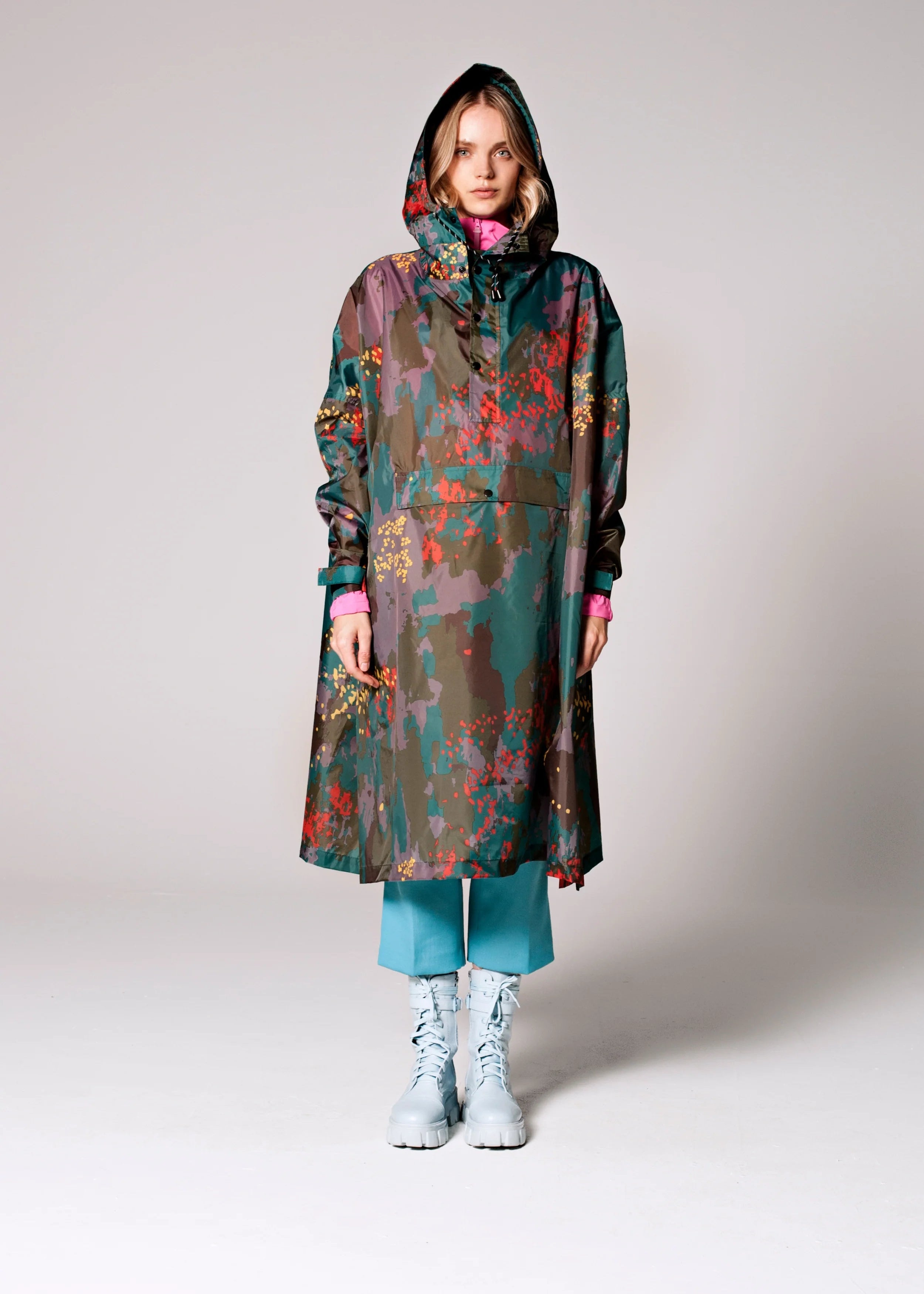 Person wearing a colorful raincoat with a pattern on a white background