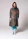 Person wearing a colorful raincoat with a pattern on a white background