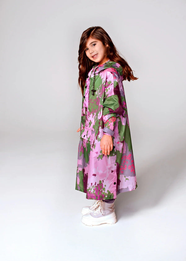Young girl wearing a pink and green floral dress on a white background