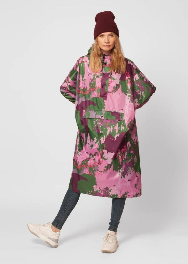 Person wearing a colorful camouflage-patterned poncho on a white background
