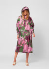 Person wearing a pink and green floral raincoat on a white background