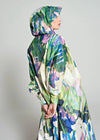 Person wearing a colorful floral-patterned raincoat against a plain background