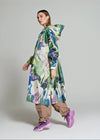 Woman wearing a colorful floral raincoat on a plain background