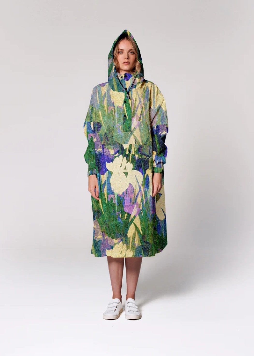 Person wearing a colorful floral-patterned raincoat on a white background