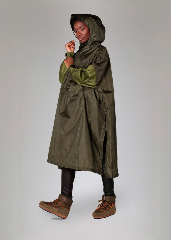 Person wearing a long green raincoat on a plain background
