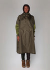 Person wearing a long green raincoat with a hood on a white background