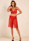 Woman wearing a red lace lingerie set on a beige background